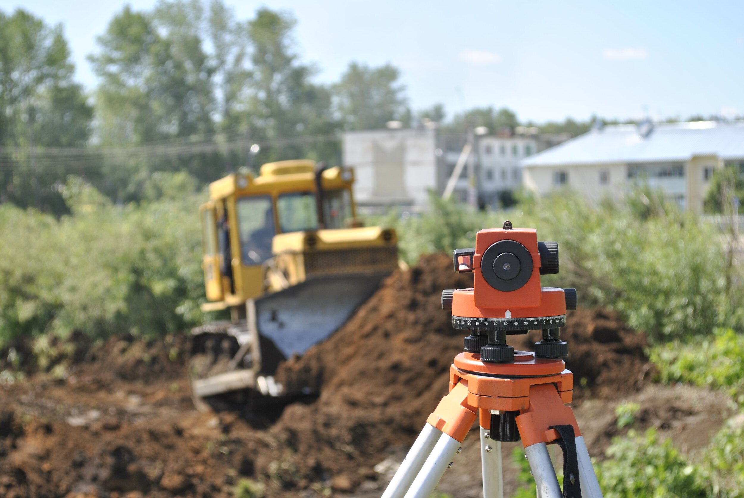Surveying equipment and a bulldozer preparing the ground